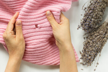 Pink sweater with a hole created from moths