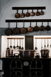 A rack mounted on a kitchen wall to organize pots and pans